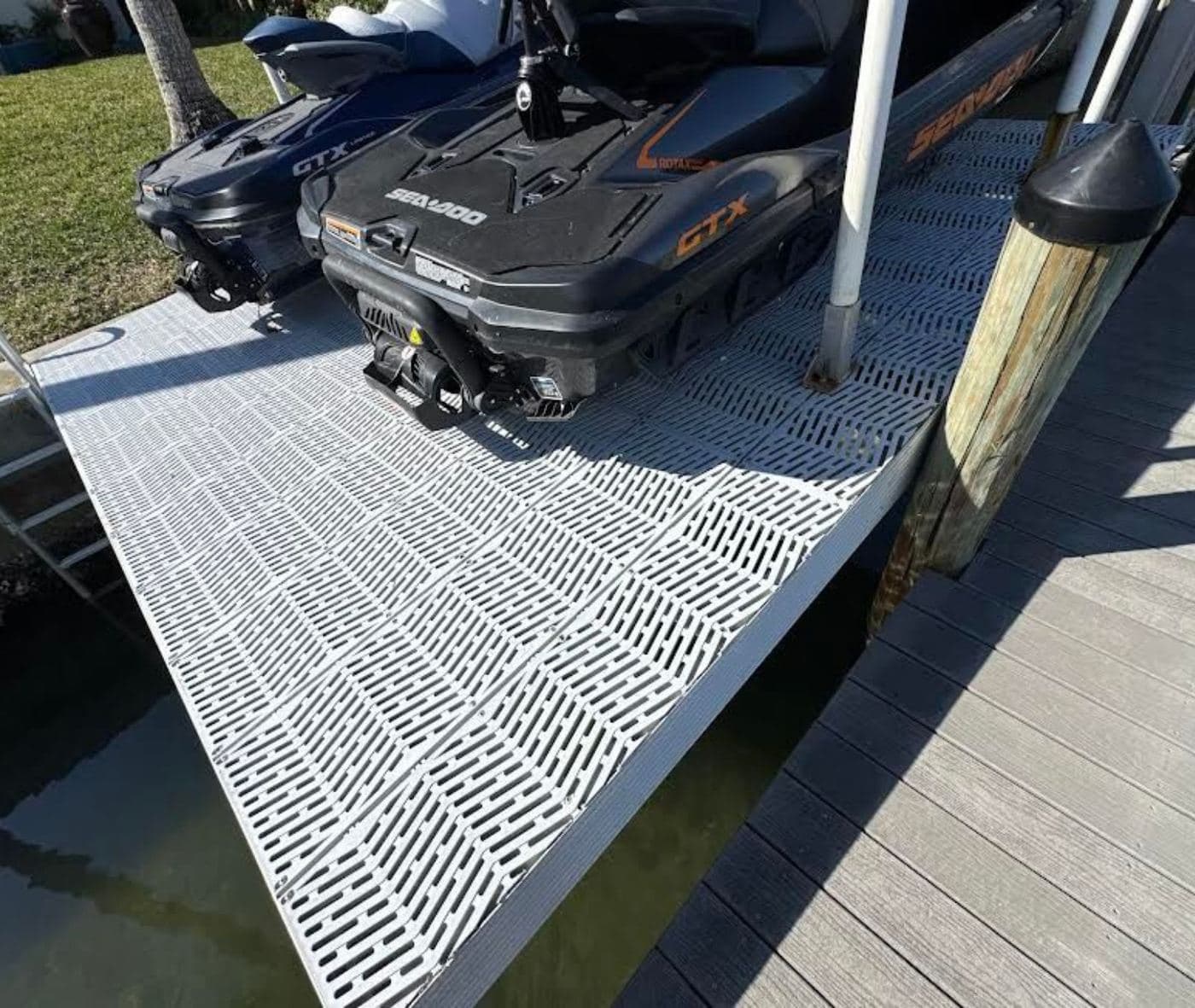 A jet ski parked on a grated drive-on platform beside a dock
