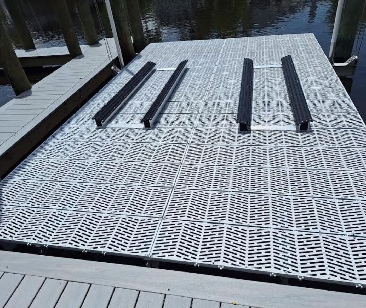 New grated decking panels and lift bunks laid out on a dock during installation