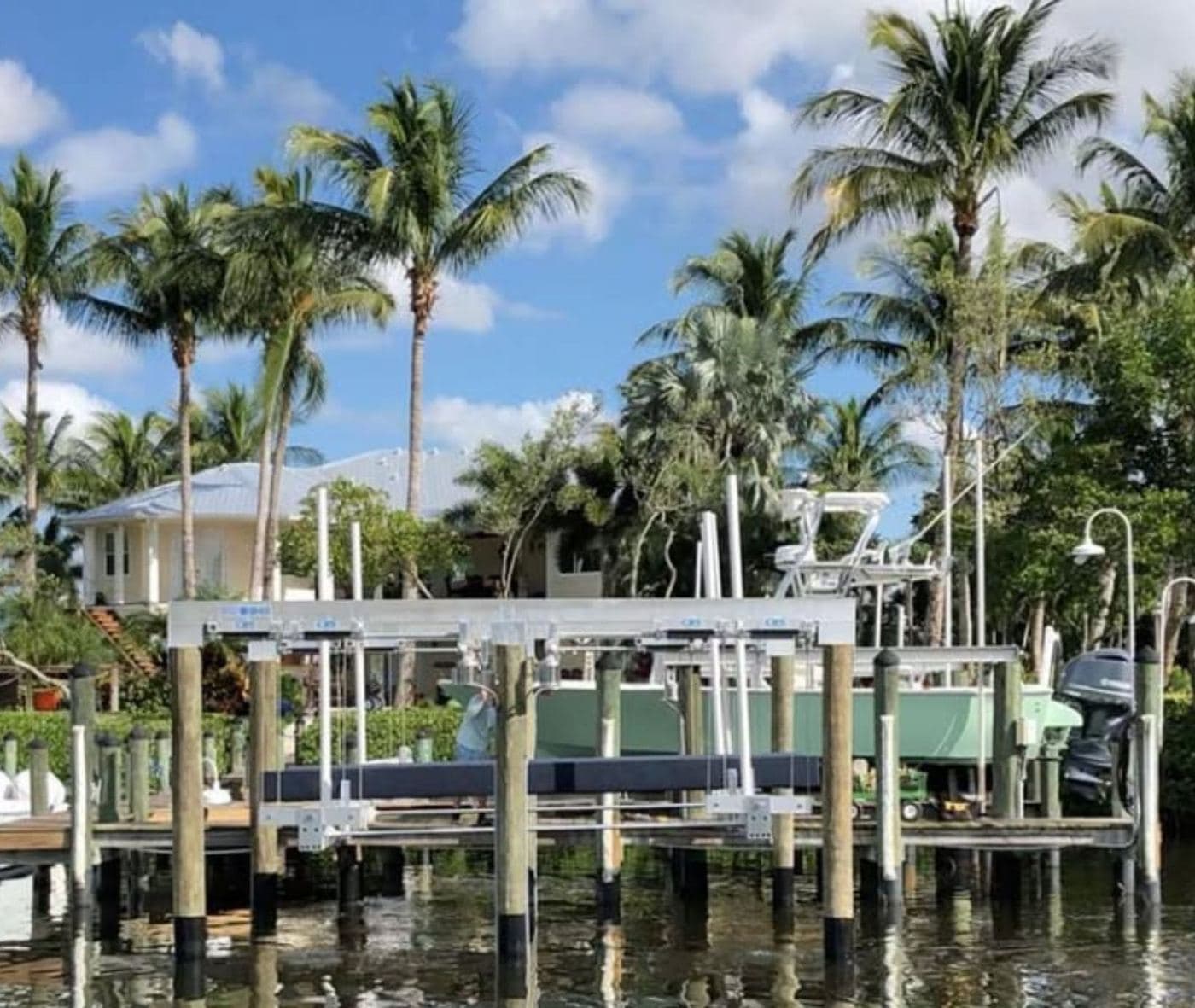 Covered docks and boat lifts along a palm-lined residential canal