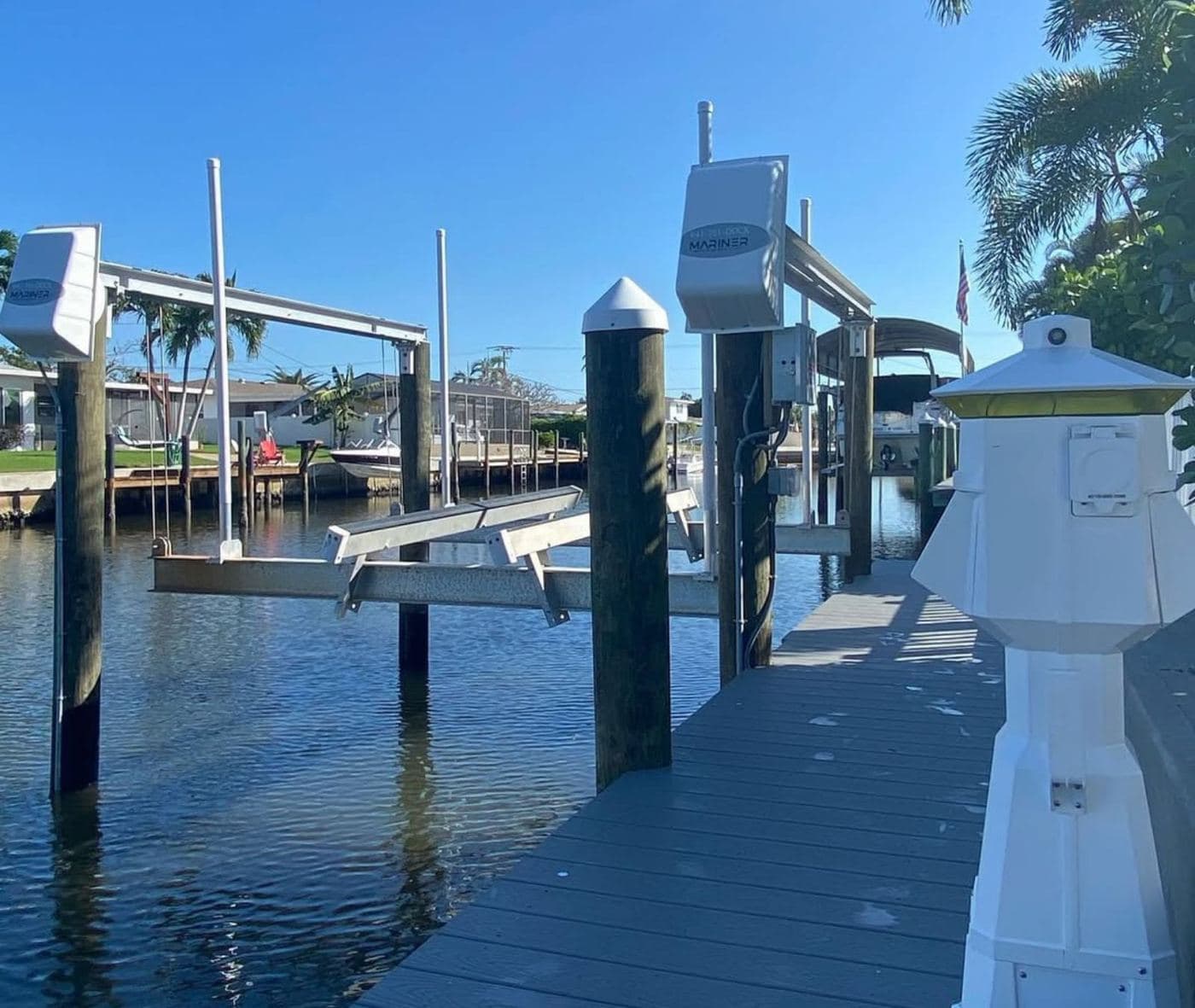 Several boat lifts and capped pilings along a canal seawall