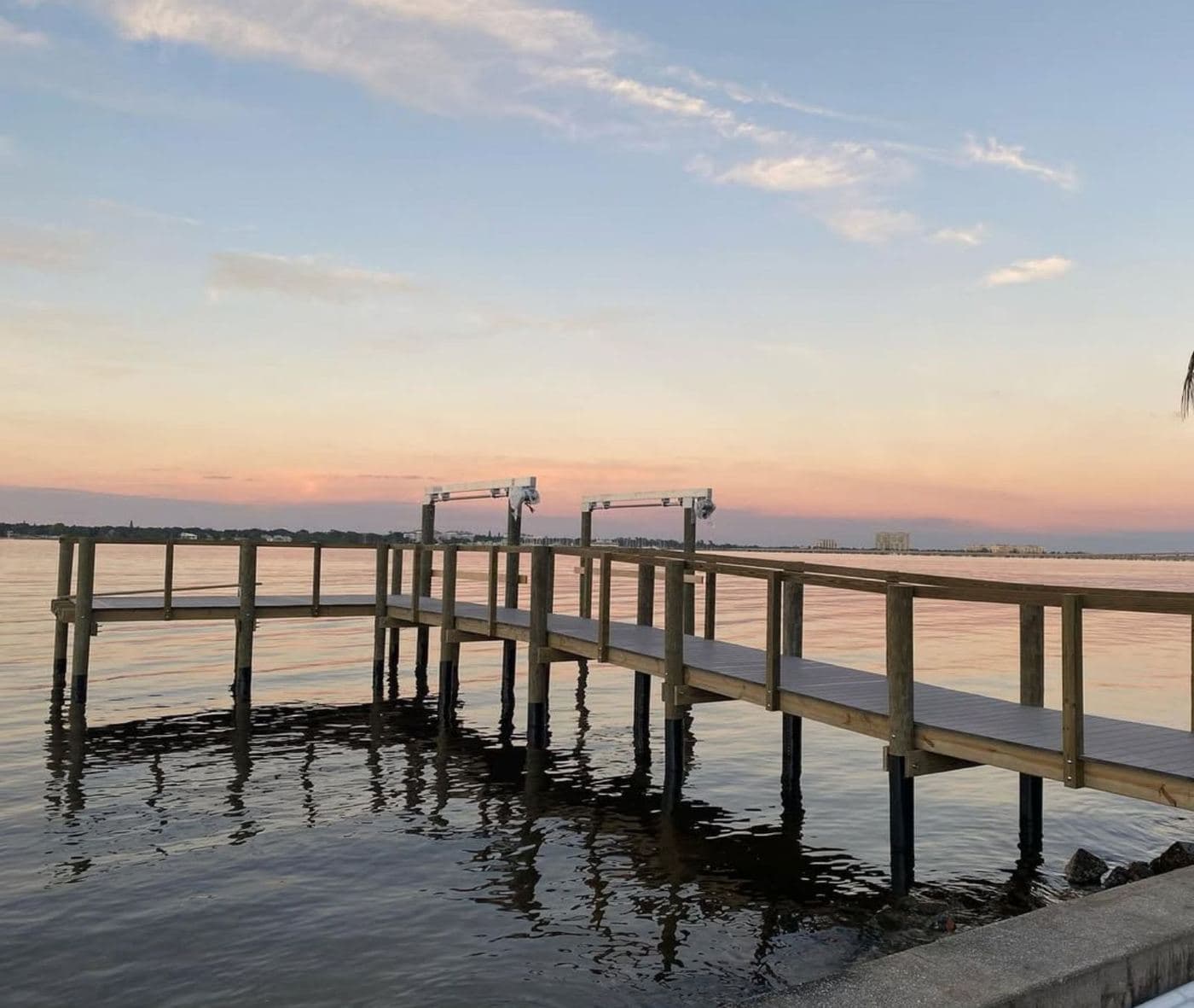 A dock silhouetted against calm water at dusk
