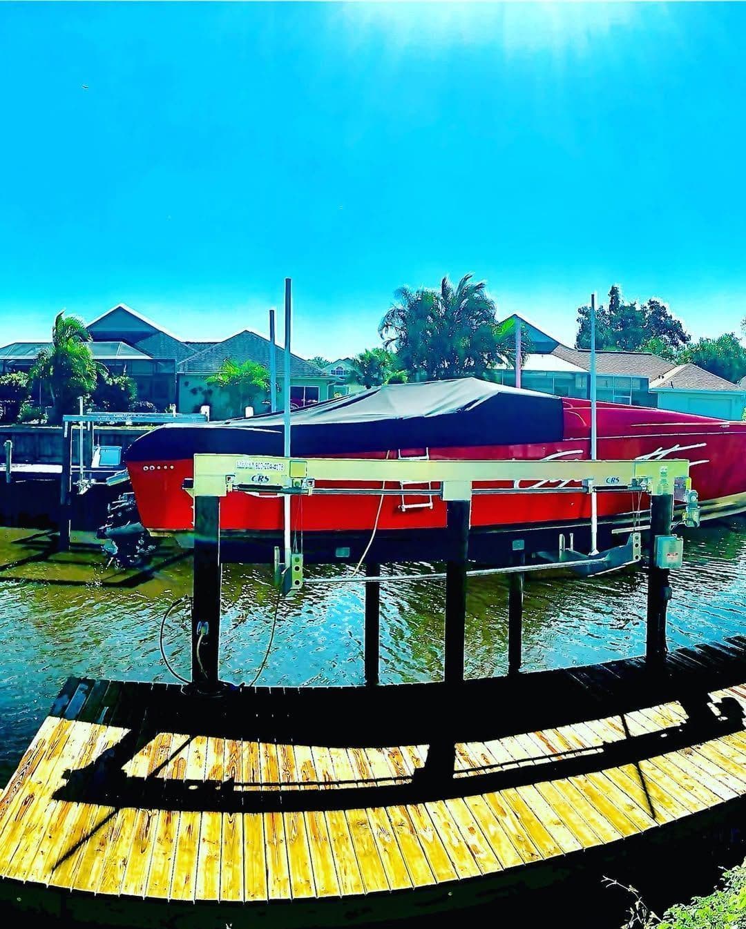 A red boat parked under a covered boat lift