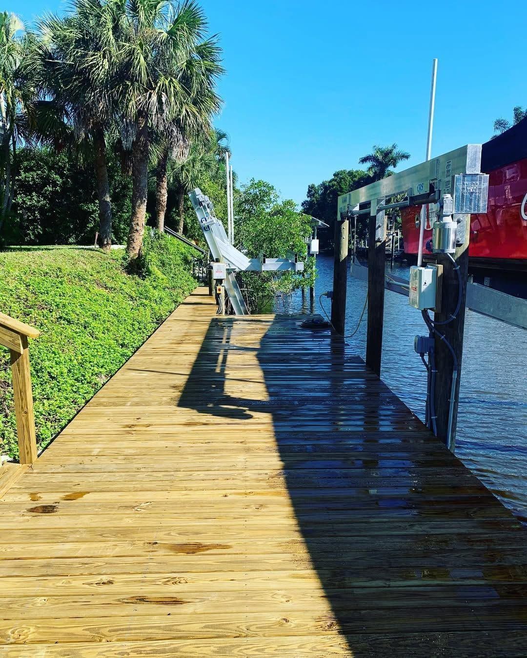 A new wooden dock walkway running down to the water through coastal vegetation