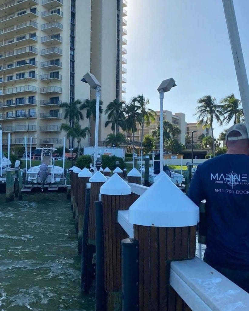 A Mariner crew member working on a dock with capped pilings