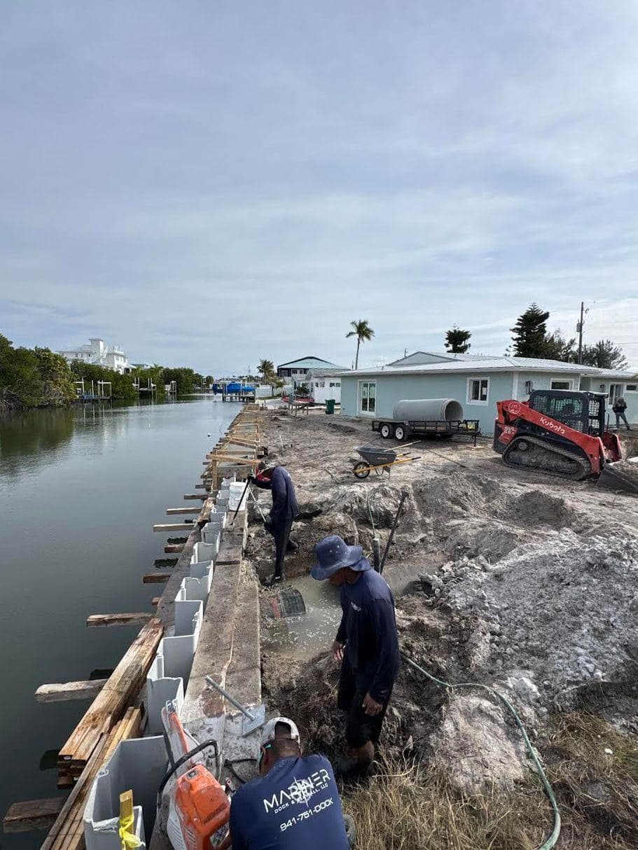 A Mariner crew member placing rip-rap along a shoreline